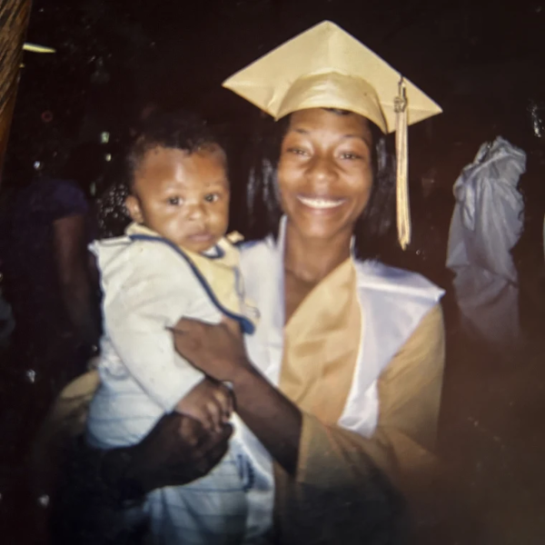 Sonya Massey in a graduation gown holding a child.