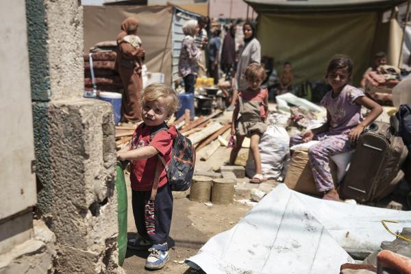 Palestinian children wait to evacuate a school that had been their shelter in eastern Deir al-Balah, Gaza Strip, August 16, 2024.