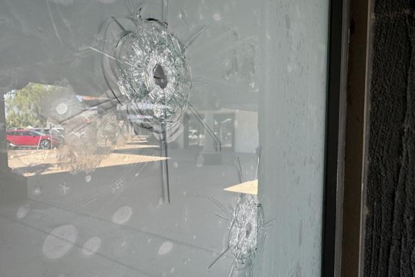 Bullet holes in glass window at Democratic Party office, Tempe, Arizona.