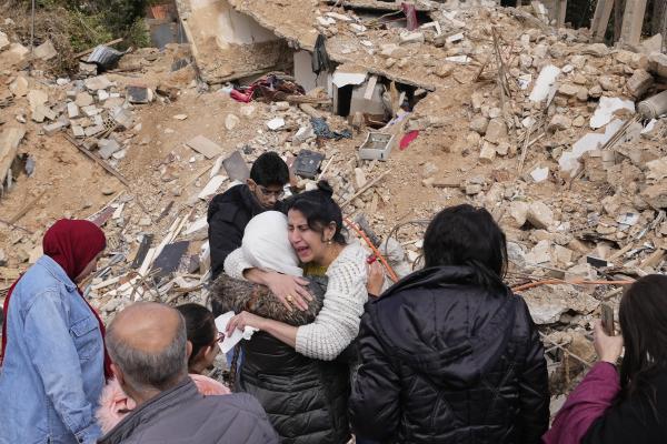 Displaced people hug each other in front of the rubble of their destroyed house in Baalbek, eastern Lebanon, November 28, 2024.