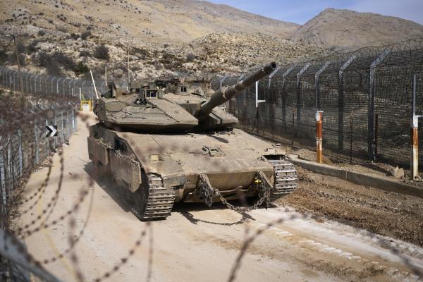 Israeli tank maneuvers next to the security fence that separates the Israeli-annexed Golan Heights from Syria, December 11, 2024.