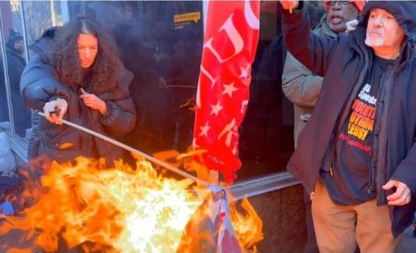 Flags burn blocks from Trump's Inauguration in a sea of MAGA fascists.