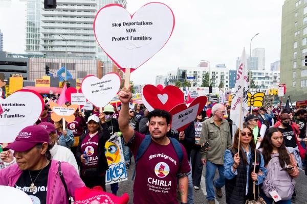 May Day march in Los Angeles. Sign in shape of heart says, Stop Deportations NOW. Protect Families