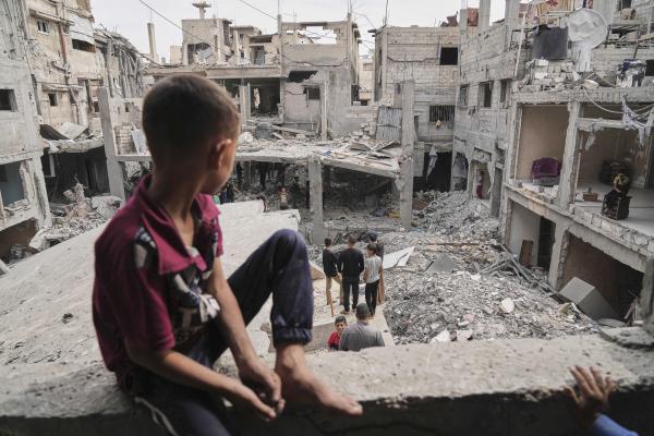 Young boy looks out over destruction of whole neighborhood from an Israeli airstrike in Khan Younis. 