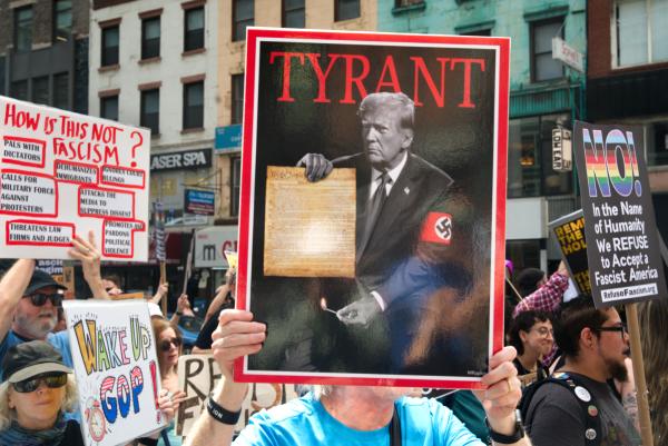 A sign with "TYRANT Trump burning up Constitution", New York City, May 17, 2025