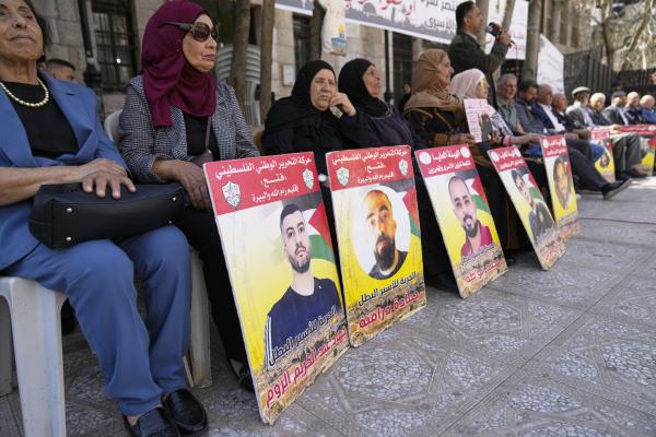 West Bank residents with posters of Palestinian friends and relatives taken prisoner by Israeli forces.