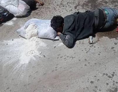 Palestinian man on the ground with punctured sack of flour. People going for supplies were fired on by Israeli forces attempting to control the crowd.