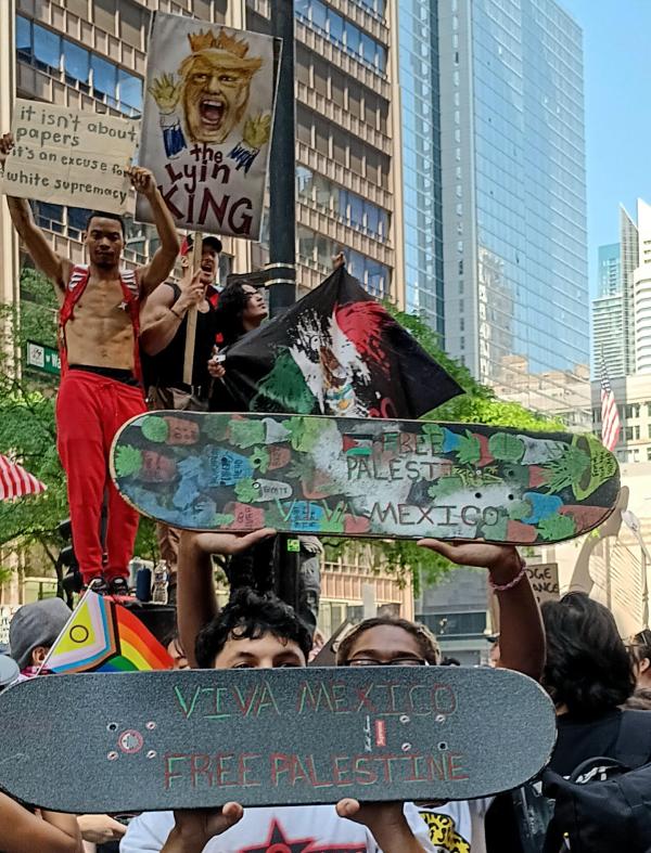Chicago No Kings protest, skateboarders with slogans on their skateboards.