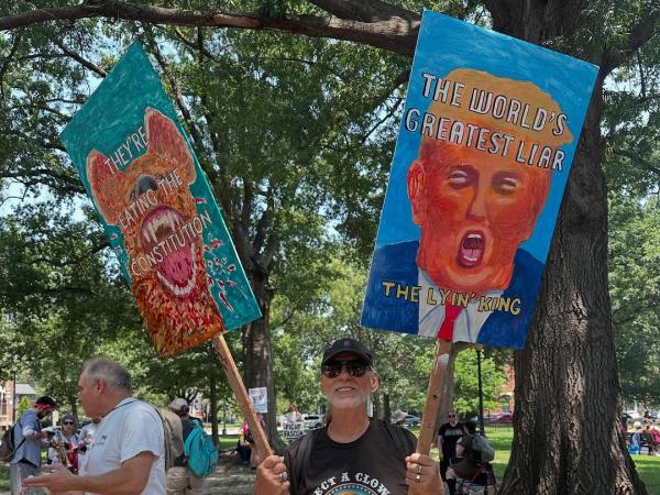 Sign at Refuse Fascism march in Washington DC: They're eating the Constitution and The world's Greatest Liar