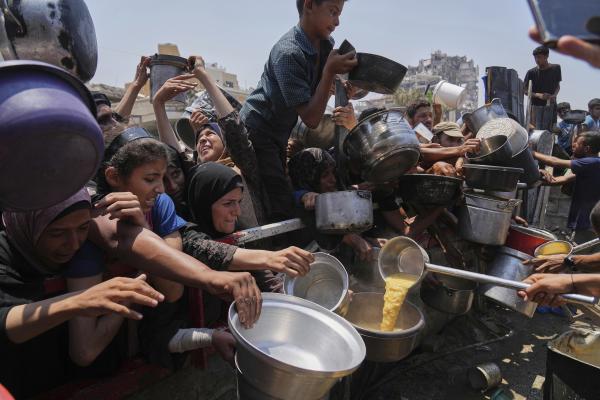 Palestinians get donated food at a community kitchen, in Gaza City, July 26, 2025.