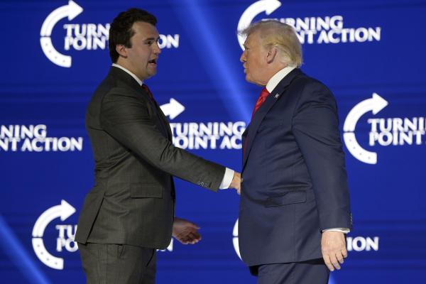 Charlie Kirk and Donald Trump shaking hands at Turning Point Summit, July 23, 2022.