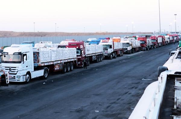 Trucks with humanitarian aid await Israeli inspection at Egyptian border before crossing into Rafah, October 20, 2025.