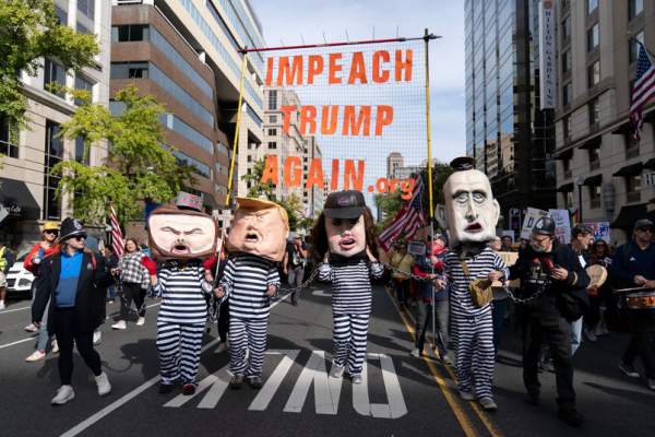 Washington DC No Kings protest: puppets of  Vance, Trump, Noem and Miller in prison stripes and chains.