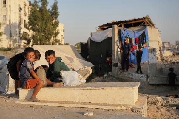 Palestinians live in makeshift tents for displaced people that were set up in a cemetery in Khan Younis, October 31, 2025.