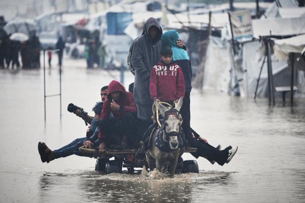 Palestinians cross area flooded by storm Byron in Khan Younis, December 11, 2025.