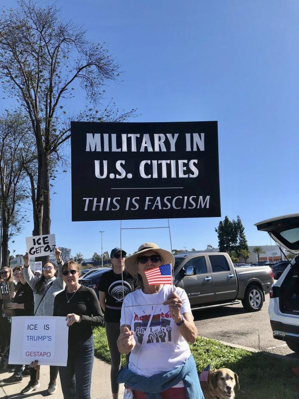 Sign holding protest: Military in U.S. cities. This is fascism.