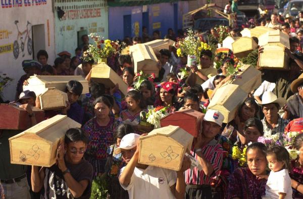 In Guatemala, the recently unearthed bodies, victims of a 1982 army massacre, are carried by relatives.