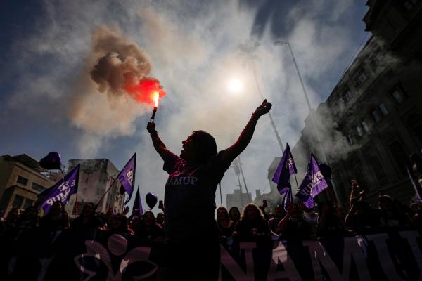 A woman waves a flare during a march marking International Women's Day in Santiago, Chile, March 8, 2025.