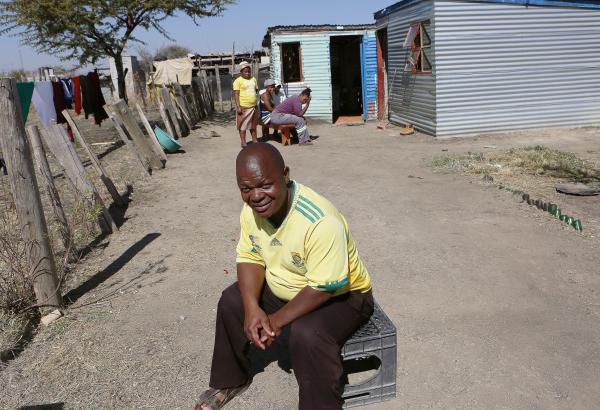 In South Africa where there is a high rate of TB, Ntutuzelo Vukani sits outside his two-room metal shack which houses five people. The shack, held together with nails hammered through rusting bottle caps, has an outdoor tap and a pit latrine toilet.