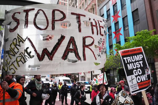 Banner Stop the War and sign Trump Must Go Now at May Day rally in Chicago, May 1, 2026.