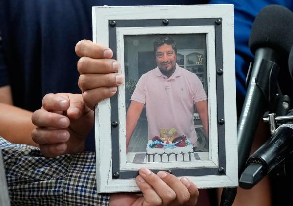 Photo of Lorenzo Salgado Araujo, murdered by ICE, held by his sons, Ronaldo and Lorenzo Jr., at news conference, July 8, 2026.
