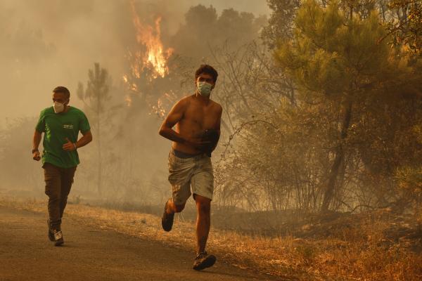 People flee a forest fire in Larouco, northwestern Spain, July 13, 2026.