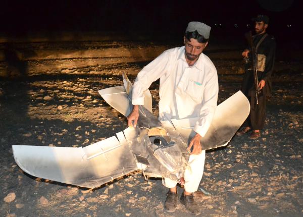 A Pakistani villager holds a wreckage of a drone