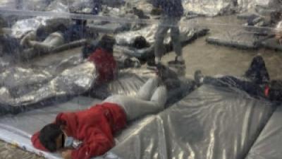 Immigrants in detention under mylar blankets