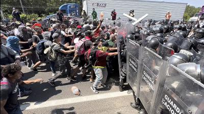 Immigrants seeking asylum in U.S. confront National Guard at border.