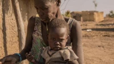 A mother giving sorghum porridge to her children. A growing number of children in South Sudan’s Northern Bahr el Ghazal and Warrap have only one meal per day.