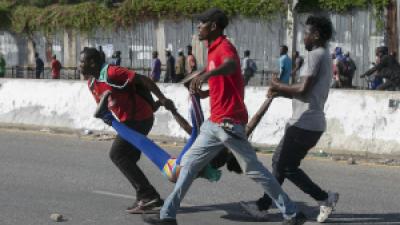 Haitian protesters carry a woman wounded in police fire, October 10, 2022.