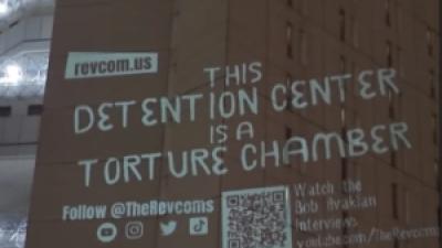 Projection on prison wall: This detention center is a torture chamber