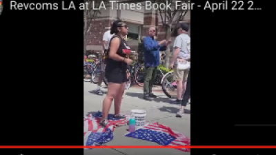 The revcoms out at the Los Angeles Times Book Fair stepping on the American flag with a display of American Crimes.