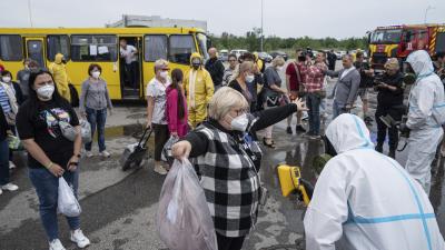 Ukrainian emergency workers wearing radiation protection suits check the radiation level of passengers of a bus in a drill near the Zaporizhzhia nuclear plant in Ukraine