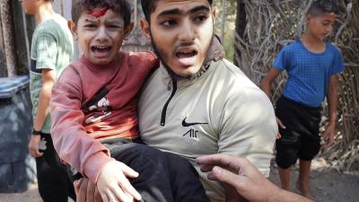 A wounded boy is carried after an Israeli strike in Deir Al-Balah, southern Gaza Strip, November 9, 2023.