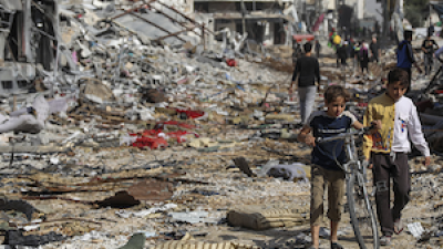 Palestinian children with bikes surrounded by the rubble of Gaza City during ceasefire, November 24, 2023.