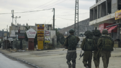 Israeli soldiers patrol a Palestinian town, with the residents all driven out by "settler" violence