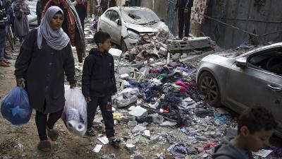 Woman and child walk through the destruction in Rafah, Gaza from Israeli airstrike, February 9, 2024,