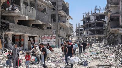 Palestinians walk through destruction after Israeli bombing of the Jabalya refugee camp in Gaza, May 30, 2024.