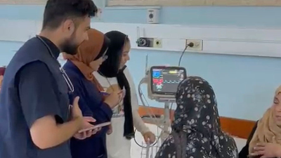 Dr. Majed Jaber (in blue vest) treating patients at European Gaza Hospital, June 2024.