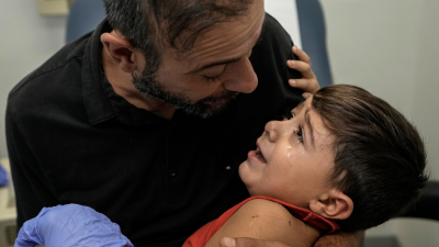 A father consoles his four-year-old, wounded by an Israeli airstrike on a densely-populated neighborhood south of Beirut, November 5, 2024.