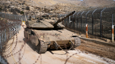 Israeli tank maneuvers next to the security fence that separates the Israeli-annexed Golan Heights from Syria, December 11, 2024.