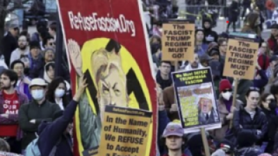 Refuse Fascism Hitler banner in middle of protest. "In the name of humanity, we refuse to accept a fascist America. 