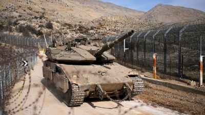 Israeli tank maneuvers next to the security fence that separates the Israeli-annexed Golan Heights from Syria, December 11, 2024.