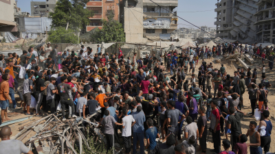 Palestinians struggle to collect humanitarian aid airdropped by parachutes into Gaza City, August 14, 2025.