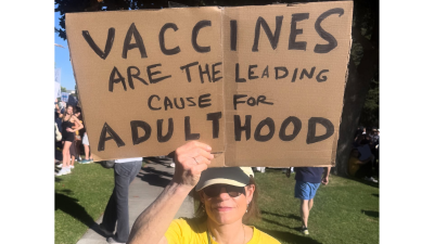 Protest sign: Vaccines are the leading cause for adulthood