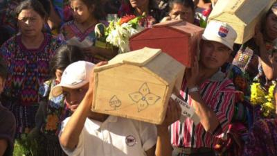 Relatives carry coffins of bodies exhumed in 2001, who were victims of a 1982 massacre by Guatemalan military at the Mayan town of Santo Tomas Chiche.