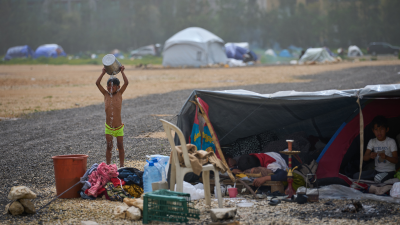 A boy in a makeshift shower after fleeing Israeli bombardment of his village in southern Lebanon, April 3, 2026.