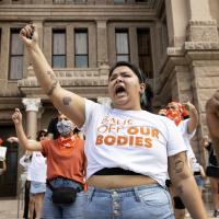 Women protest Texas six-week ban on abortion on Austin capitol steps.
