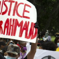 Woman holding sign "Justice for Ahmaud"